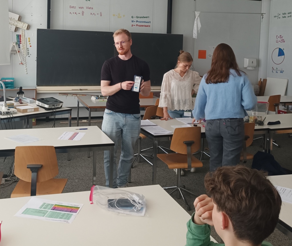 Project GOLIAT investigators instructing study participants on the use of the exposimeter for personal measurements during a school visit.